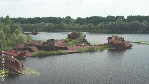 Close-up shot of the decayed abandoned river freighters at the contaminated Pripyat river (Chernobyl exclusino zone). Scene ends with a panning shot. photo