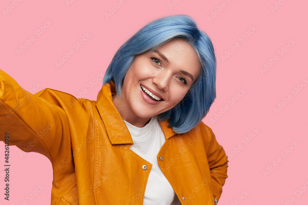 Trendy smiling woman taking selfie in studio Trendy smiling woman taking selfie in studio