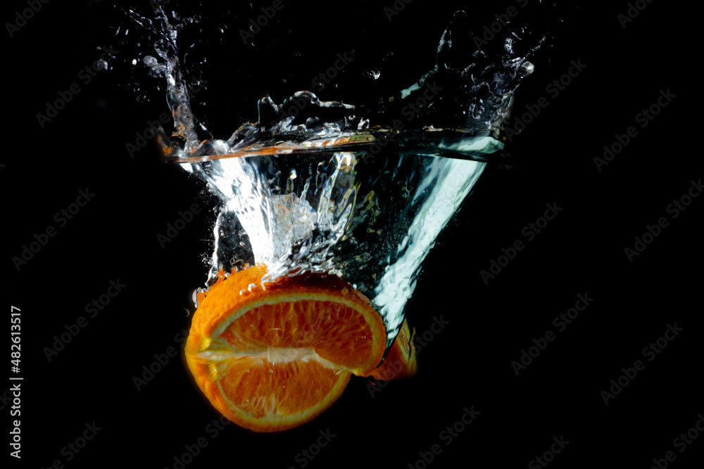 Fototapeta premium Colorful orange splashing into water