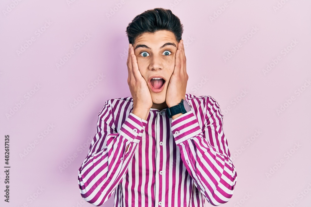 Young hispanic man wearing casual clothes afraid and shocked, surprise and amazed expression with hands on face Young hispanic man wearing casual clothes afraid and shocked, surprise and amazed expression with hands on face