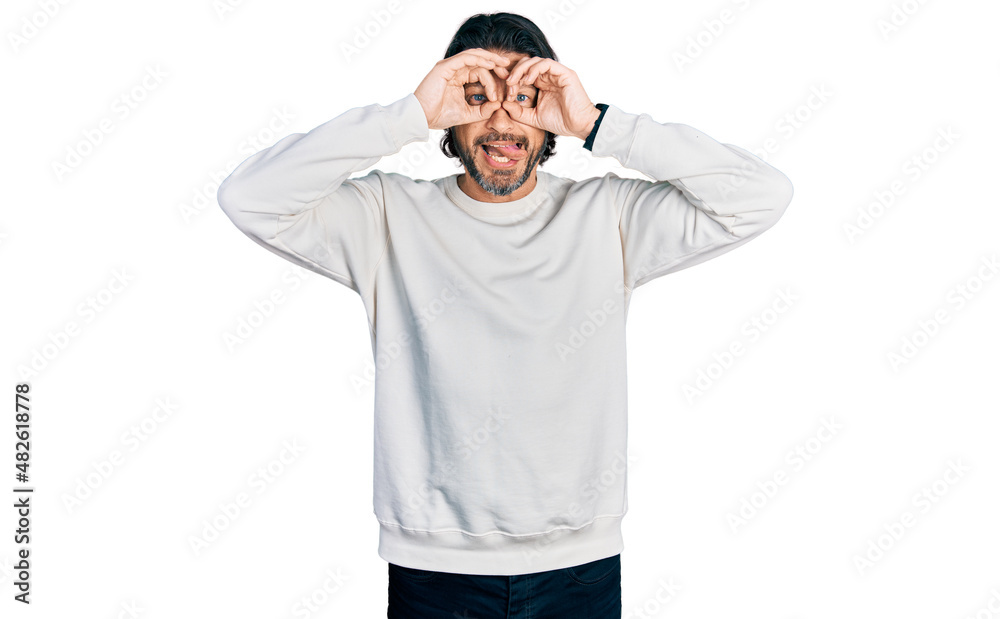 Middle age caucasian man wearing casual clothes doing ok gesture like binoculars sticking tongue out, eyes looking through fingers. crazy expression. Middle age caucasian man wearing casual clothes doing ok gesture like binoculars sticking tongue out, eyes looking through fingers. crazy expression.