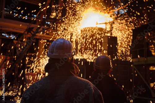 Metallurgists during the process of pouring steel from a ladle.
Ingot casting, metal sparks. Ladle-furnace. Iron smelting, Steel production. Electric steel furnace. Metallurgy. Industry steel producti