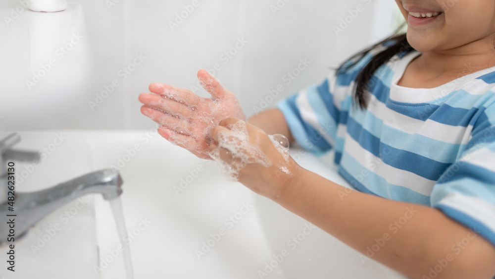 Little Asian girls wash their hands in the bathroom. Soft focus. Copy space. Little Asian girls wash their hands in the bathroom. Soft focus. Copy space.