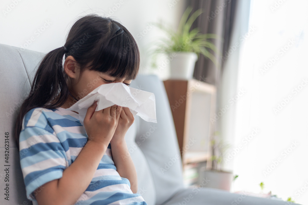 Unhealthy kid blowing nose into tissue, Child suffering from running nose or sneezing, A girl catches a cold when season change, childhood wiping nose with tissue Unhealthy kid blowing nose into tissue, Child suffering from running nose or sneezing, A girl catches a cold when season change, childhood wiping nose with tissue