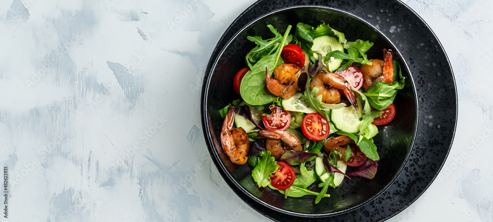 Seafood salad with smoked shrimps, cherry tomatoes, cucumber and mixed leaves. Healthy eating concept. Detox diet. Vegetarian lunch. Weight loss, top view Seafood salad with smoked shrimps, cherry tomatoes, cucumber and mixed leaves. Healthy eating concept. Detox diet. Vegetarian lunch. Weight loss, top view