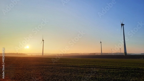 Lever de soleil sur un champ d'éoliennes à la campagne