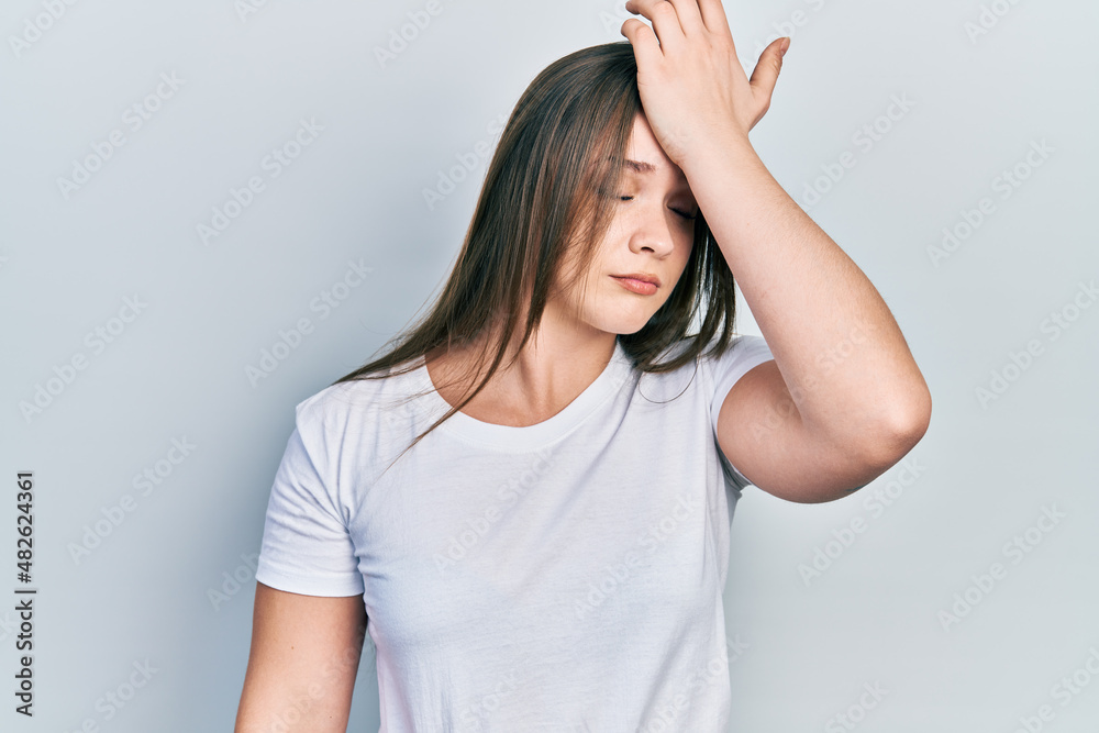 Young hispanic girl wearing casual white t shirt surprised with hand on head for mistake, remember error. forgot, bad memory concept. Young hispanic girl wearing casual white t shirt surprised with hand on head for mistake, remember error. forgot, bad memory concept.