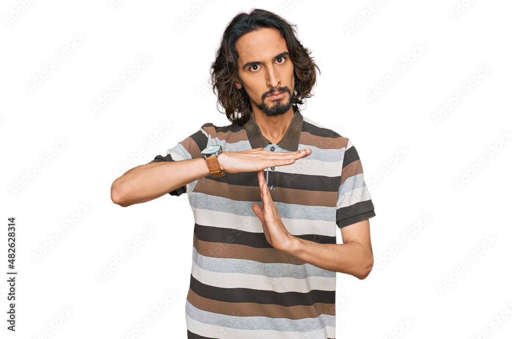 Young hispanic man wearing casual clothes doing time out gesture with hands, frustrated and serious face Young hispanic man wearing casual clothes doing time out gesture with hands, frustrated and serious face