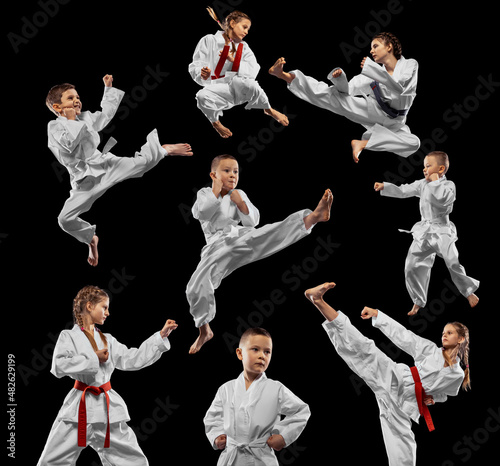 Group of young girls and boys, taekwondo athletes training together isolated over dark background. Concept of sport, education, skills