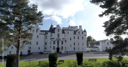 Low aerial pull back, parallax shot of Blair Castle flying the Scottish Flag of the Saltire. photo