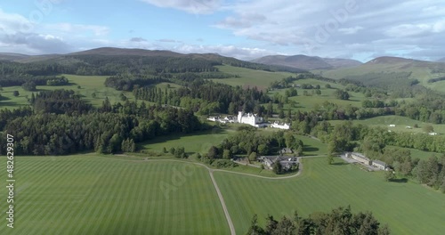 High aerial shot and push in towards Blair Castle over green fields and gardens. photo