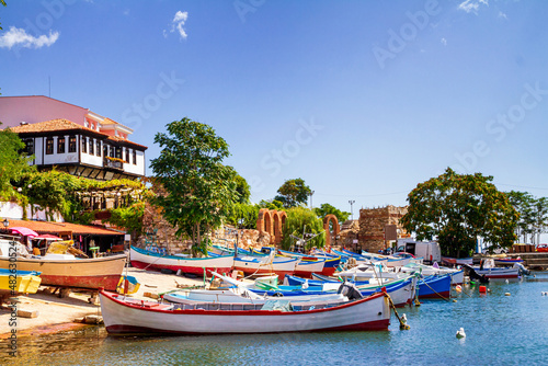 Seaside cityscape - view of the pier with boats and embankment in the Old Town of Nessebar, on the Black Sea coast of Bulgaria photo