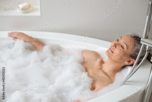Female lying in the bathtube in spa