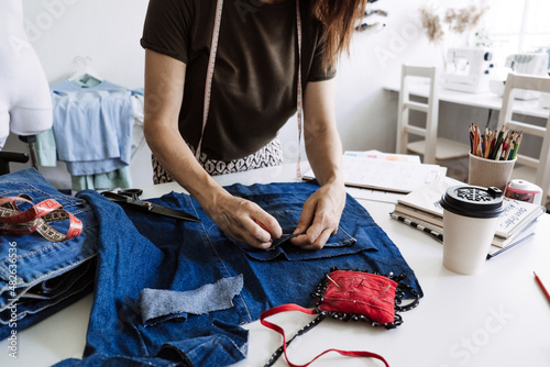 Mending Clothes, how to mend old Clothes. Sustainable fashion, Denim Upcycling Ideas, Using Old Jeans, Repurposing, Reusing Old Jeans, Upcycle Stuff. Woman seamstress cut and repair old blue jeans