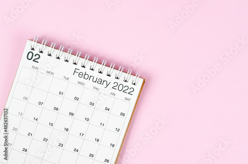 February 2022 desk calendar on pink background with empty space.