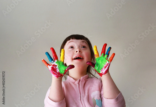 Cute little kid with painted hands. Isolated on grey background.