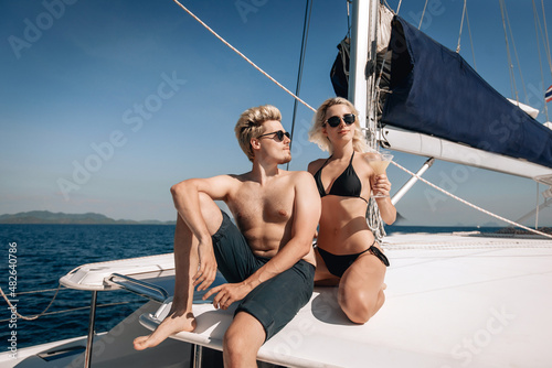 Portrait of an independent and beautiful male and female movels in sweamsuits posing for the camera and looking into the distance. Attractive girl holding a glass with a cold drink in her hand