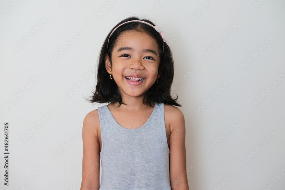 Asian kid standing and looking to the camera with happy face expression Asian kid standing and looking to the camera with happy face expression