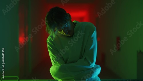 A mad male patient in straitjacket is going crazy in a mental hospital. Mentally ill man with psychic disorders and bipolar disease. Concept of paranoia or schizophrenia and madness or depression.