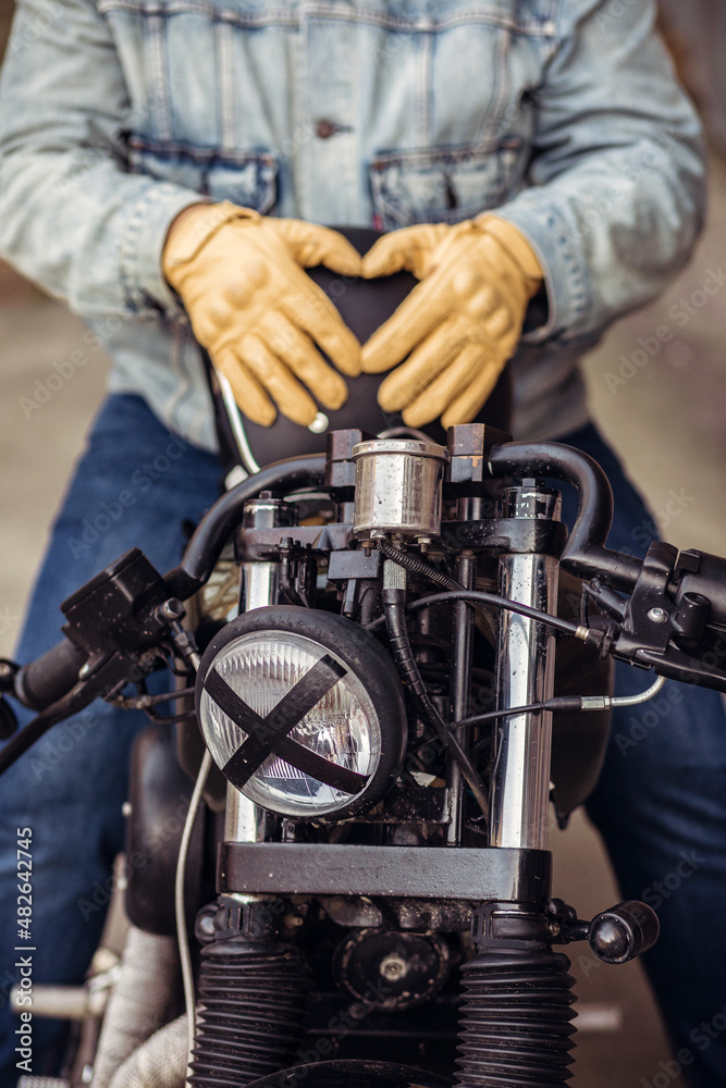 Close up set of an attractive driver. Close up motorcycle detail. Black helmet and yellow gloves of a motorcycle driver. Hipster lifestyle. Outdoor concept Close up set of an attractive driver. Close up motorcycle detail. Black helmet and yellow gloves of a motorcycle driver. Hipster lifestyle. Outdoor concept