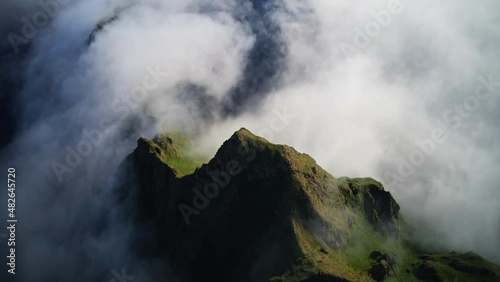 Awesome timelapse. White clouds flows above green peak edge. Aerial panorama