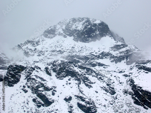 The dark rocky terrain covered with snow after the fresh snowfall at Nathula Pass, Indo-China border situated at 14,500 ft altitude in Sikkim. Temperature is Deeping up to - 10 celsius with cold.