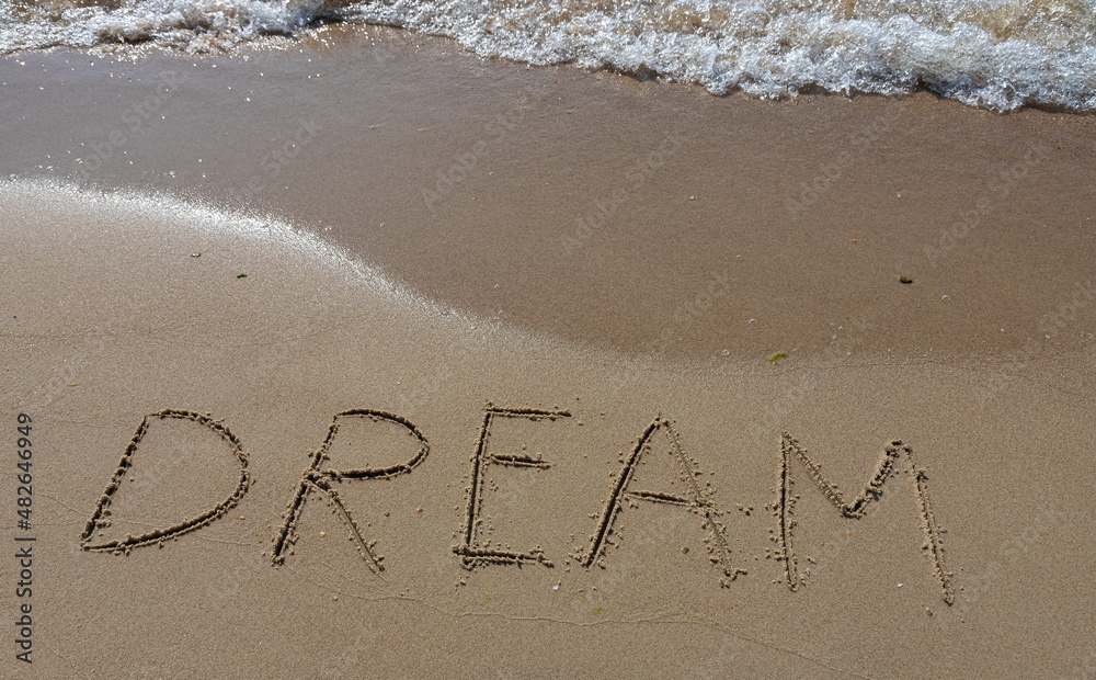 Fototapeta premium the inscription DREAM on the sand of the coastline