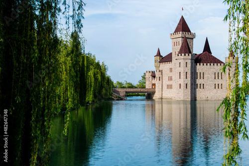 The castle stands on a blooming green lake, surrounded by a beautiful park area.