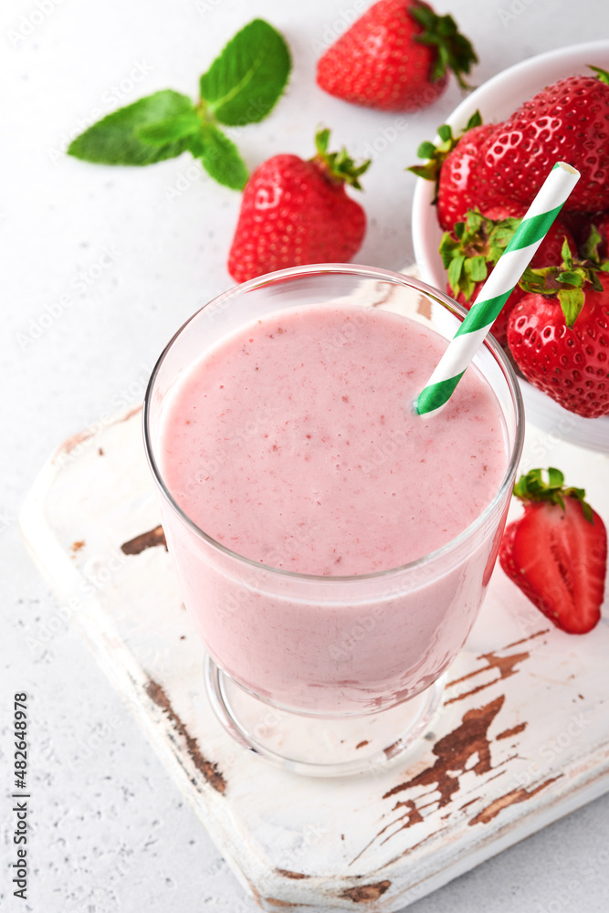 Fruit smoothie. Strawberry smoothie or milkshake with berries and mint in tall glass on light grey background. Summer drink shake, milkshake and refreshment organic concept. Place for text. Fruit smoothie. Strawberry smoothie or milkshake with berries and mint in tall glass on light grey background. Summer drink shake, milkshake and refreshment organic concept. Place for text.