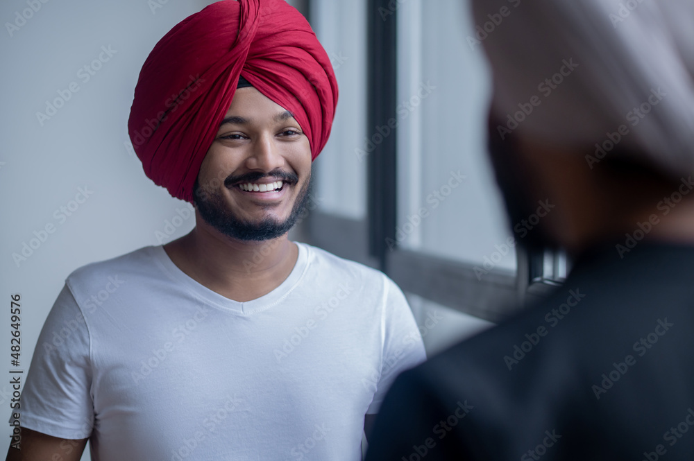 Two men in turbans talking and looking involved