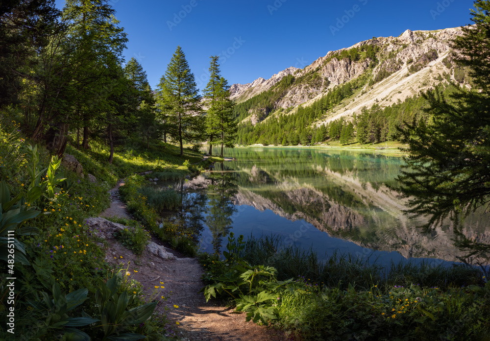 Orceyrette Lake in Summer with larch tree forest. Briancon Region in the Hautes-Alpes. Southern French Alps, France