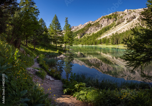 Orceyrette Lake in Summer with larch tree forest. Briancon Region in the Hautes-Alpes. Southern French Alps, France
