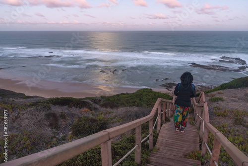 Woman at sunrise on the access stairs to Carriagem Beach. Aljezur. Algarve photo