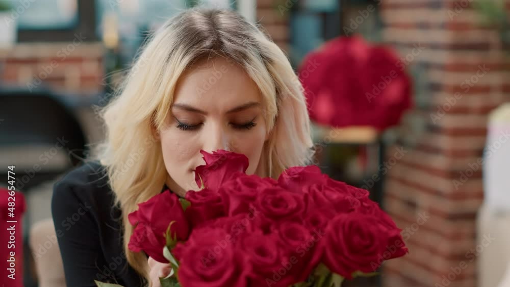 Portrait of seductive woman in love smelling red rose and looking at camera enjoying valentine day luxury gift. Romantic affectionate blonde admiring flowers arrangement celebrating anniversary. Portrait of seductive woman in love smelling red rose and looking at camera enjoying valentine day luxury gift. Romantic affectionate blonde admiring flowers arrangement celebrating anniversary.