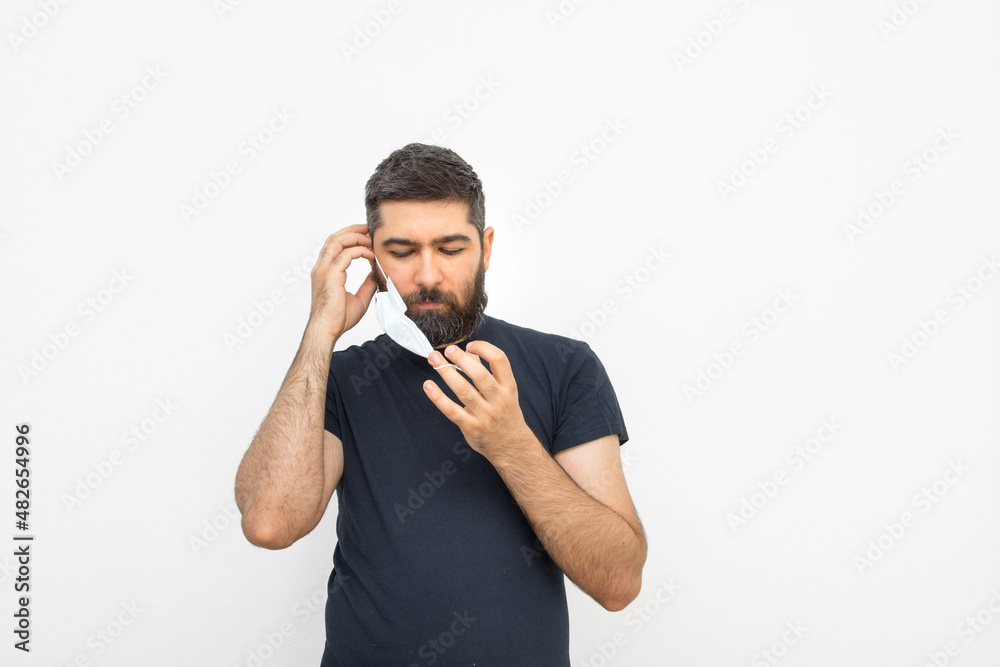 A young man with a beard and masks. Security measures. Masked man. Isolated background. A young man with a beard and masks. Security measures. Masked man. Isolated background.