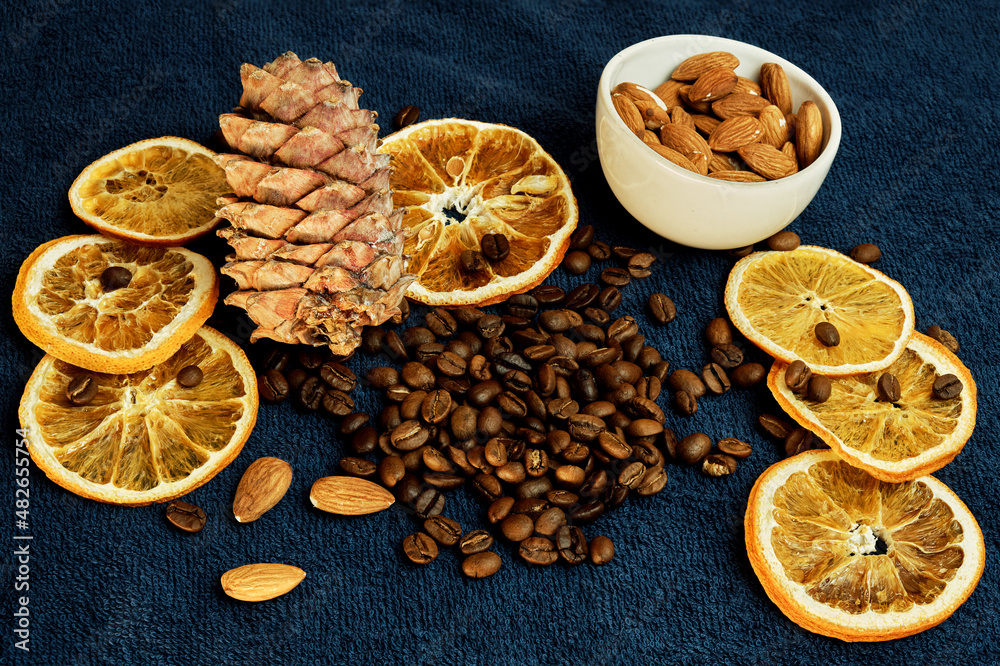 set of orange, cedar cones, almonds in a cup and coffee beans