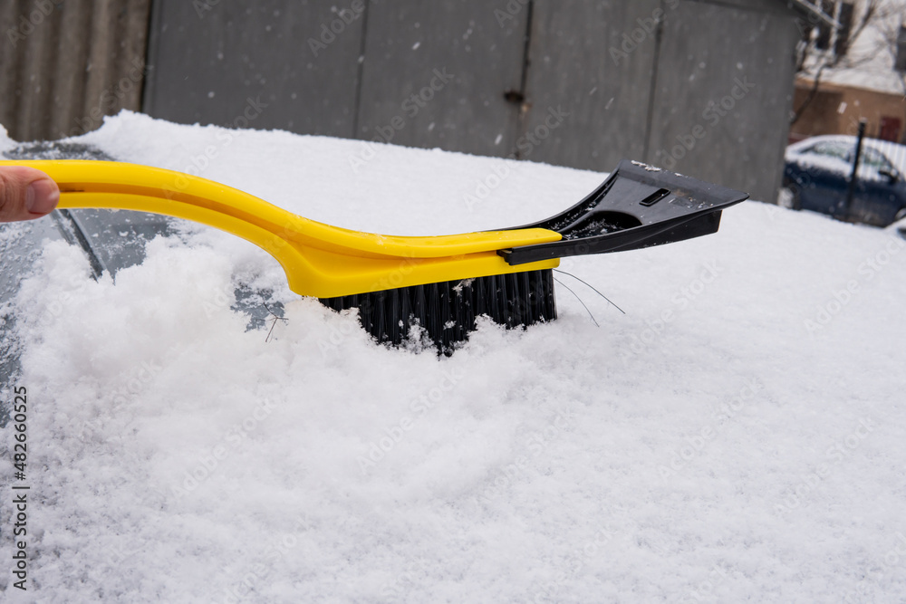 cleaning the car from snow with a brush cleaning the car from snow with a brush