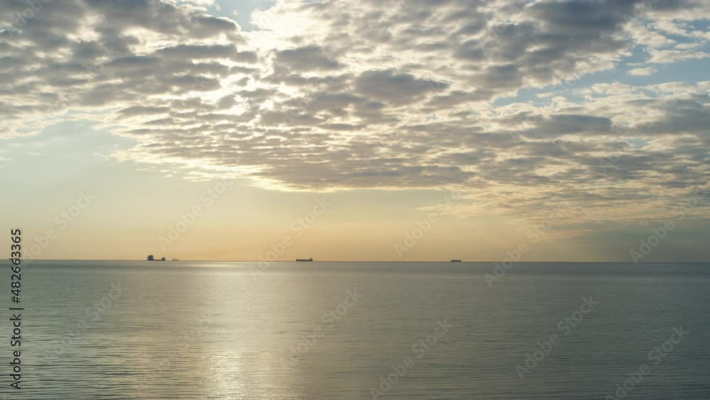 Beautiful sea horizon sky shining sunset clouds in majestic nature background.