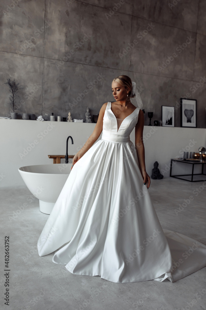 The bride wears a white wedding dress. Wedding preparations. Morning of the bride in the bathroom. The bride wears a white wedding dress. Wedding preparations. Morning of the bride in the bathroom.