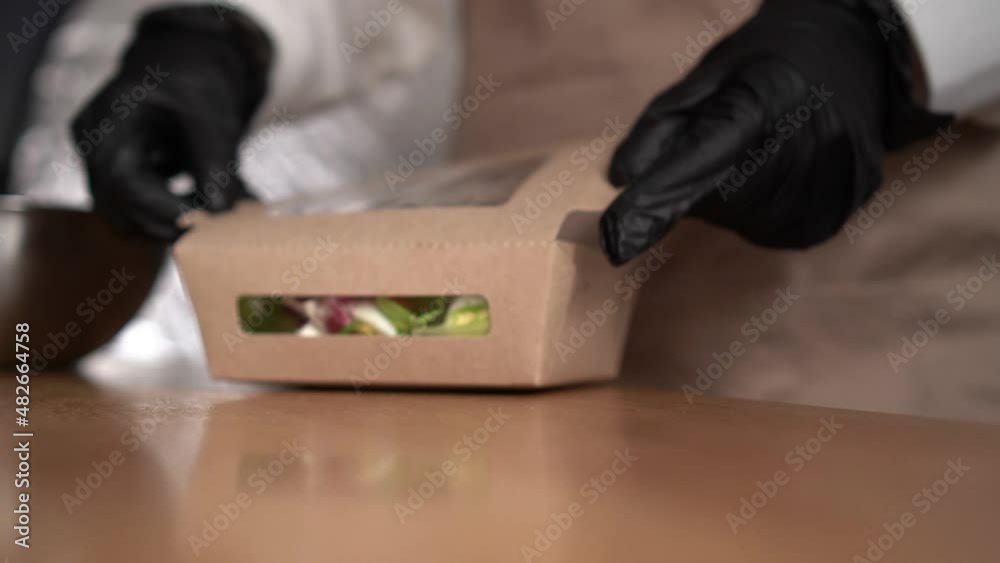 Food delivery services. Restaurant worker collecting a food box take away