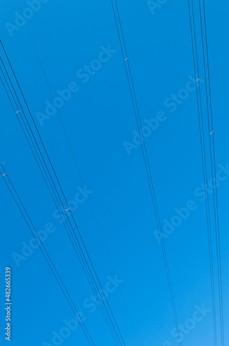 High voltage power line cables on blue sky