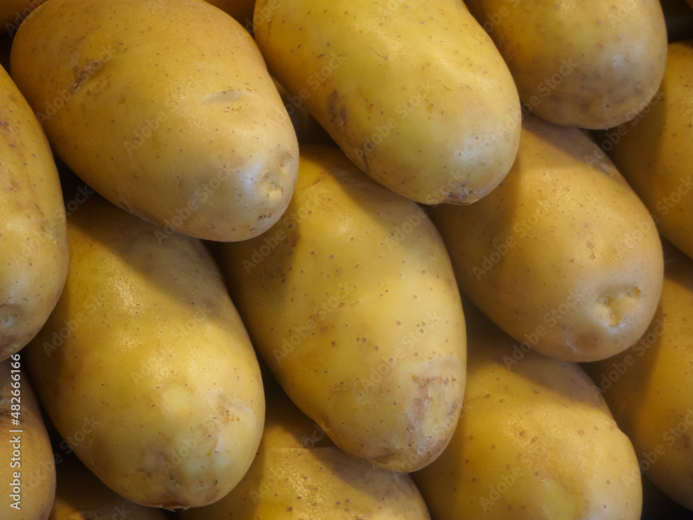 Close-up shot of Neatly stacked large Russet potatoes on a stall Close-up shot of Neatly stacked large Russet potatoes on a stall