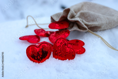 Fototapeta Naklejka Na Ścianę i Meble -  red hearts on the snow. heart symbol of romantic love, background for holiday. Copy space. St. Valentine's Day.