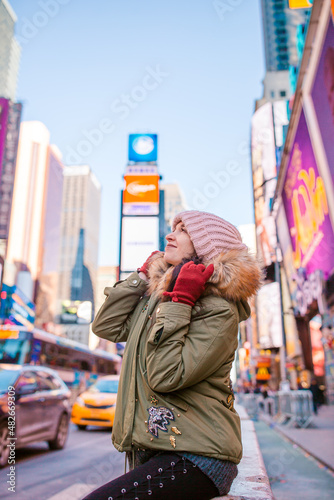 New York City woman on Times Square. Beautiful young happy smiling girl on Manhattan, New York City, New York, USA.
