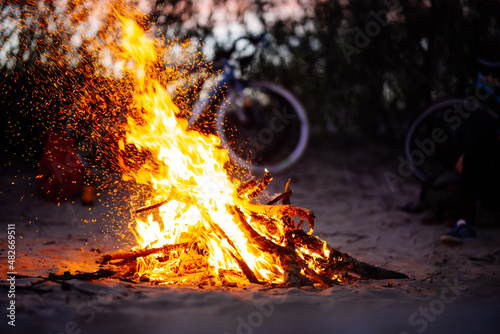 Fototapeta Beach bonfire burning with sparks flying around
