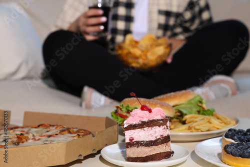 Overweight woman with chips, focus on unhealthy food