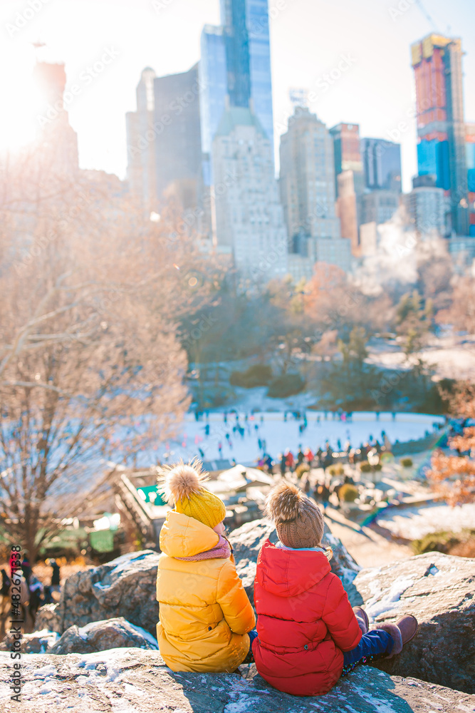 Adorable little girls with view of ice-rink in Central Park at New York City