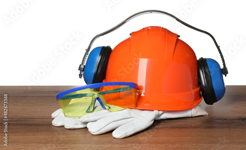Personal protective equipment on wooden surface against white background