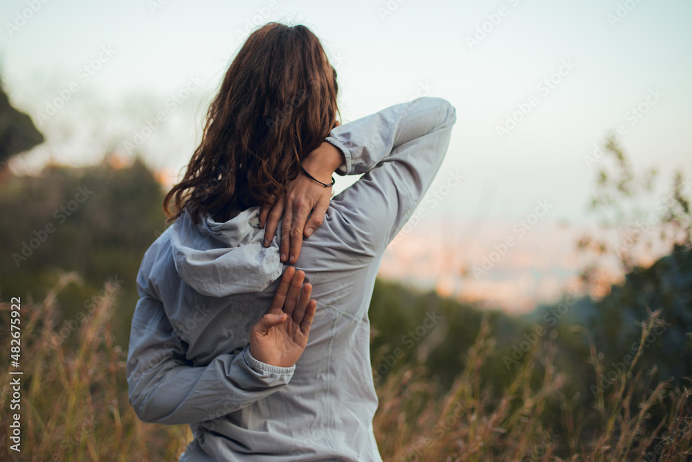 Girl doing stretching before outdoor running session looking at Barcelona city Girl doing stretching before outdoor running session looking at Barcelona city