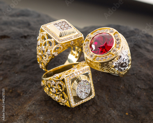 gold jewelry. Men's rings with gold color stones on black stone.